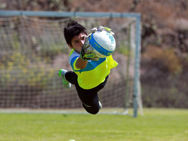 One Soccer School player catching soccer ball in front of the goal